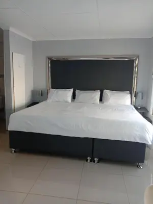 a bedroom with a large bed with white sheets and pillows at Tony Hill Manor House in Shirley