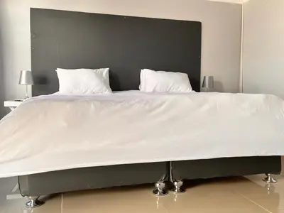a large white bed with two pillows on it at Tony Hill Manor House in Shirley