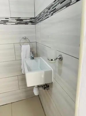 a bathroom with a white sink on the wall at Tony Hill Manor House in Shirley