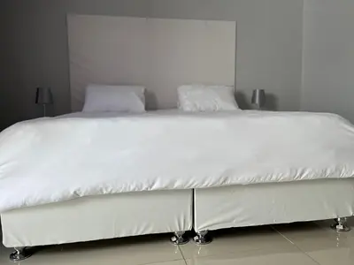 a white bed with white sheets and pillows on it at Tony Hill Manor House in Shirley
