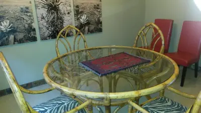a glass table and chairs with a plate on top of it at 5th Seasons Guesthouse in Nelspruit