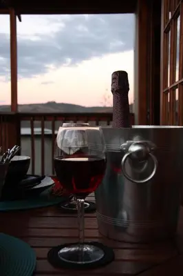 a glass of wine sitting on top of a table at 5th Seasons Guesthouse in Nelspruit