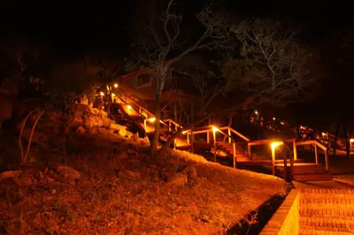 a house with lights on a hill at night at 5th Seasons Guesthouse in Nelspruit
