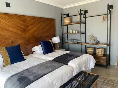 a bedroom with a large bed with a wooden headboard at Maratongfontein Euphoria Villa in Naboomspruit