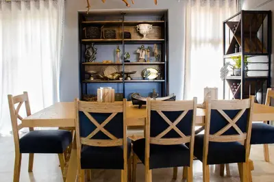 a dining room with a wooden table and chairs at Maratongfontein Euphoria Villa in Naboomspruit