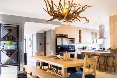 a large kitchen with a wooden table and chairs at Maratongfontein Euphoria Villa in Naboomspruit
