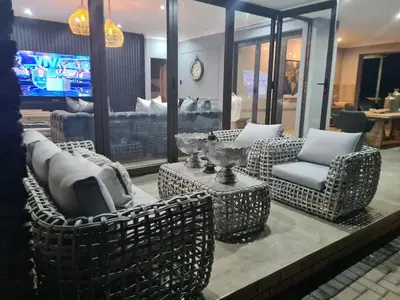 a living room with couches and chairs and a tv at Maratongfontein Euphoria Villa in Naboomspruit