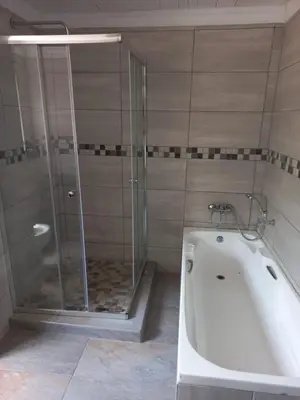 a bathroom with a shower and a bath tub at Chasba Airbnb in Hartbeespoort
