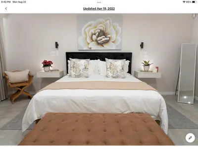 a bedroom with a large bed with a large flower on the wall at Rueby’s Apartment 101 in Dullstroom