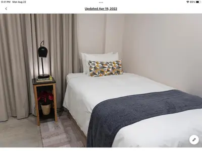 a bedroom with two beds and a lamp on a table at Rueby’s Apartment 101 in Dullstroom