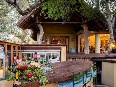 a wooden table in front of a restaurant at Shimungwe Lodge, Thornybush Game Reserve in Hoedspruit