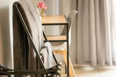 a chair with a towel on it next to a table at VillaZek a modern 2 bedroom open- plan apartment with parking in Pretoria