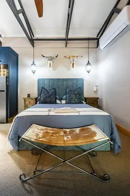 a bedroom with a large bed with a blue headboard at Grace of Africa Boutique Safari Lodge in Marloth Park