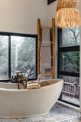 a bath tub in a bathroom with a window at Grace of Africa Boutique Safari Lodge in Marloth Park