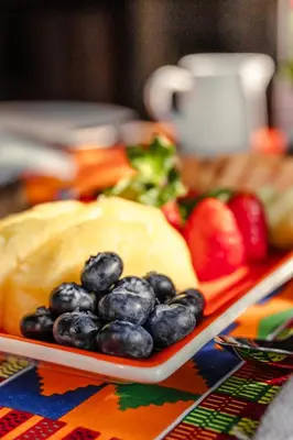 a plate of blueberries and fruit on a table at Grace of Africa Boutique Safari Lodge in Marloth Park