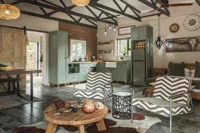 a kitchen with green cabinets and a table and chairs at Grace of Africa Boutique Safari Lodge in Marloth Park