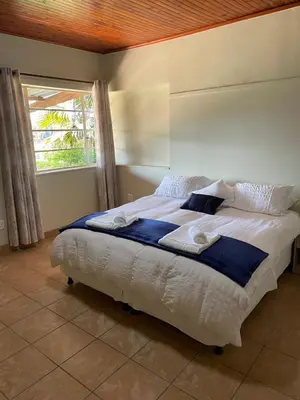 a bedroom with a large bed with a window at Enon in Haenertsburg