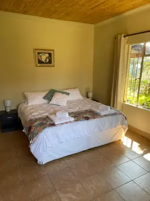 a bedroom with a bed in a room with a window at Enon in Haenertsburg