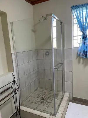 a shower with a glass door in a bathroom at Enon in Haenertsburg