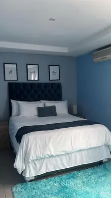 a blue bedroom with a large bed with a blue wall at Mo'Acress Lifestyle in Temba