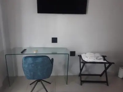 a glass desk with a blue chair and a table at Mo'Acress Lifestyle in Temba