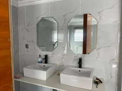 a bathroom with two sinks and two mirrors at Mo'Acress Lifestyle in Temba