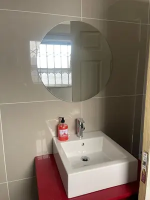 a bathroom with a white sink and a mirror at Mo'Acress Lifestyle in Temba