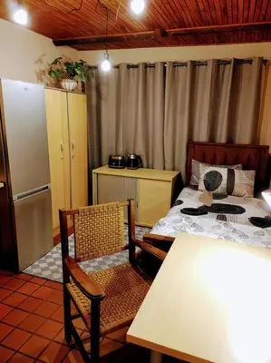 a bedroom with a bed and a table and chairs at Casa'Roma in Pretoria