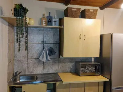 a kitchen with a sink and a stainless steel refrigerator at Casa'Roma in Pretoria