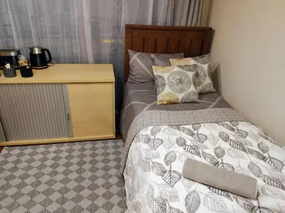a bedroom with a bed and a night stand at Casa'Roma in Pretoria