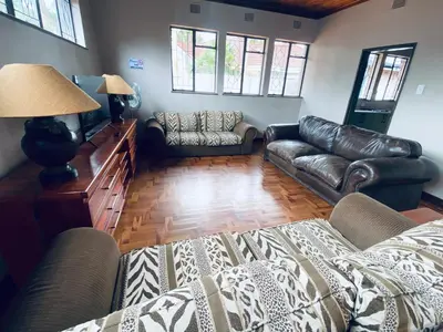 a living room with leather furniture and a couch at Oost Street in Polokwane