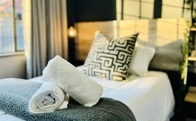 a hotel room with a bed with towels on it at Oost Street in Polokwane