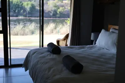 a bedroom with a bed with two pillows on it at Waterberg Game Lodge in Bela-Bela