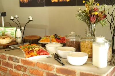 a table topped with plates of food and flowers at Waterberg Game Lodge in Bela-Bela