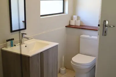a bathroom with a sink and a toilet and a window at Waterberg Game Lodge in Bela-Bela
