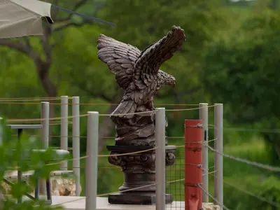 a statue of an eagle on top of a fence at Phomola Manor Holiday Home in Phalaborwa