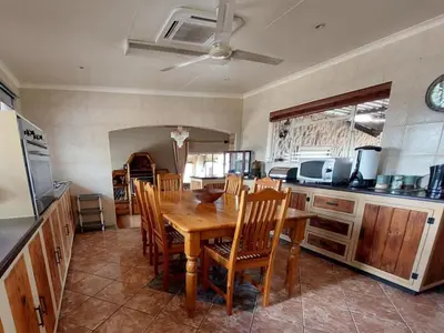 a kitchen with a wooden table and chairs at Phomola Manor Holiday Home in Phalaborwa