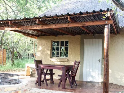 a wooden table and chairs on a patio at Cottage@Injabulo in Marloth Park