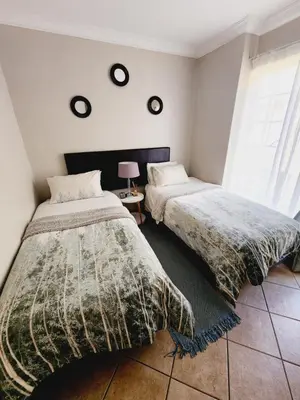 a bedroom with two beds and a window at Red Peppers in Pretoria