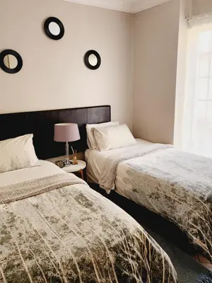 a bedroom with two beds and a window at Red Peppers in Pretoria