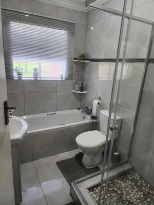 a bathroom with a toilet and a tub and a sink at Red Peppers in Pretoria