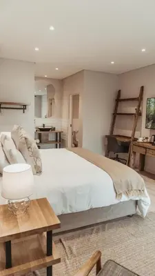 a bedroom with a large bed and a desk at 55 Tulbagh events and wedding venue in Kempton Park