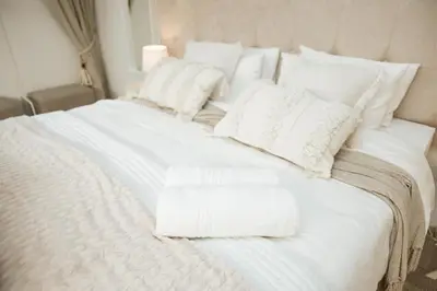 a white bed with white blankets and pillows on it at 55 Tulbagh events and wedding venue in Kempton Park