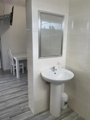 a bathroom with a sink and a mirror and a table at 22 on Mirabel in Kempton Park