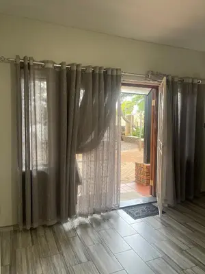 a room with curtains and a sliding glass door at 22 on Mirabel in Kempton Park