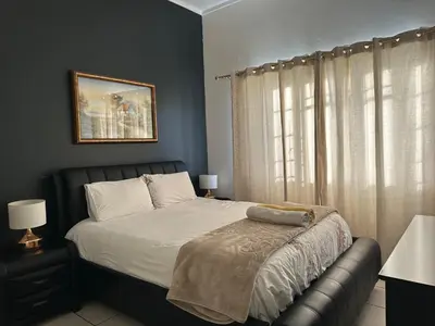 a bedroom with a bed and a window at The Classic Menlyn Maine Apartment in Pretoria