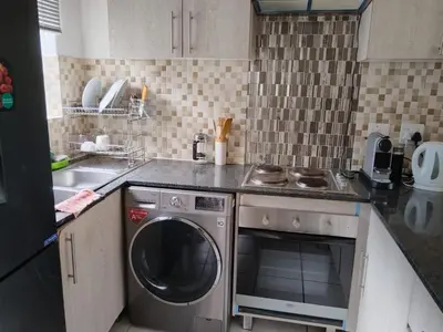 a kitchen with a washing machine and a sink at The Classic Menlyn Maine Apartment in Pretoria