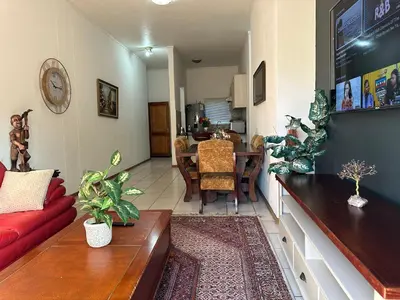 a living room with a red couch and a table at The Classic Menlyn Maine Apartment in Pretoria