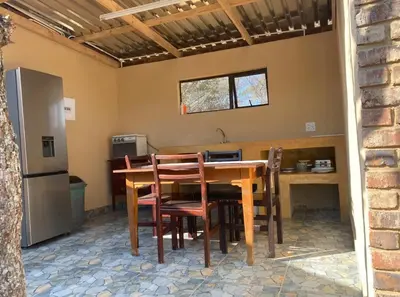 a kitchen with a table and chairs and a refrigerator at Vlakkieskraal Farmstay - Nyala Tented Camp in Bela-Bela