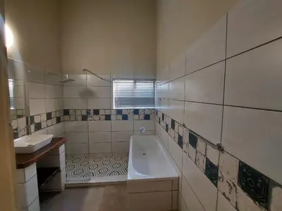 a bathroom with a tub and a sink at Stoep At Kruger in Komatipoort